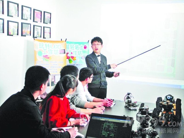 奥松机器人创始人于欣龙（站立者）与其团队成员正在研讨方案